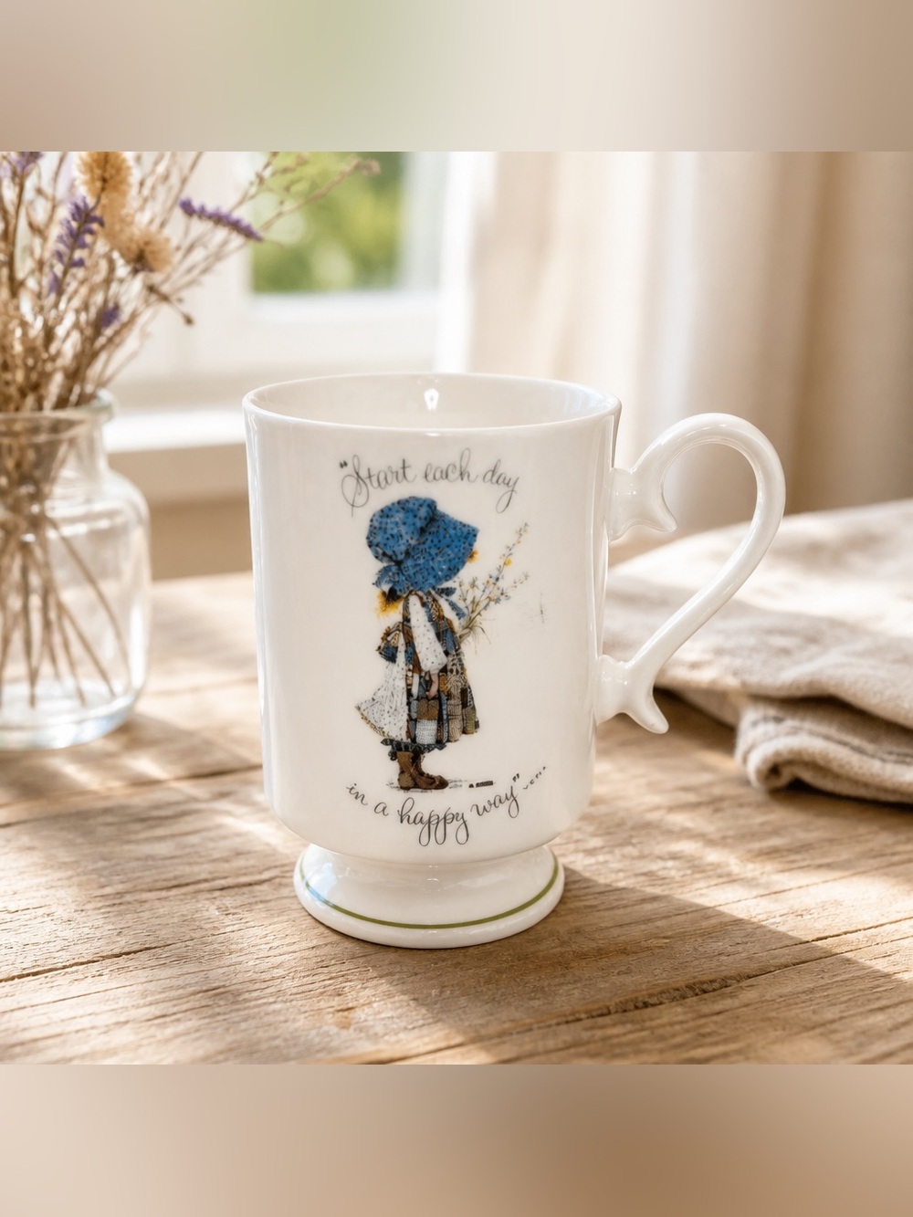 Holly Hobbie porcelain pedestal mug features Start Each Day in a Happy Way